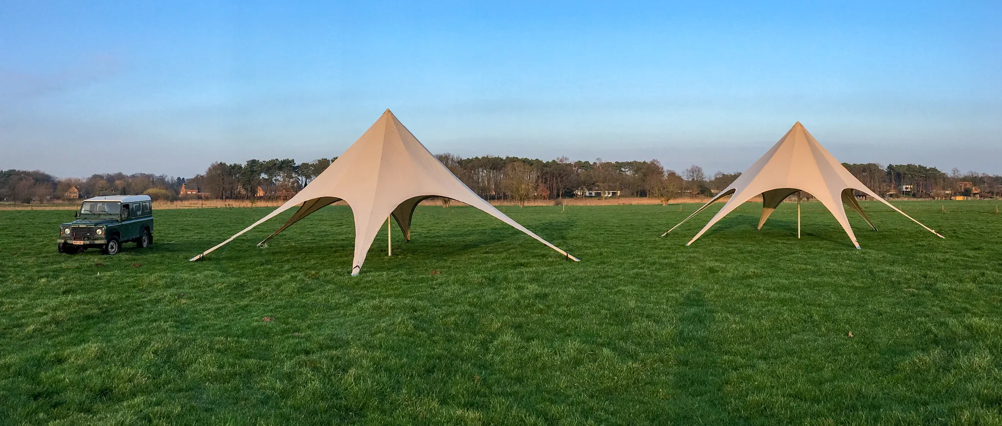 Twee stertenten van TenD op een grote grasweide bij zonsopgang